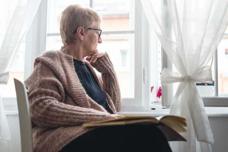 Senior woman relaxing and reflecting as a way to improve her spiritual wellness.