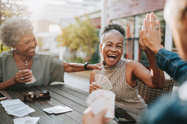 Senior women friends playing cards